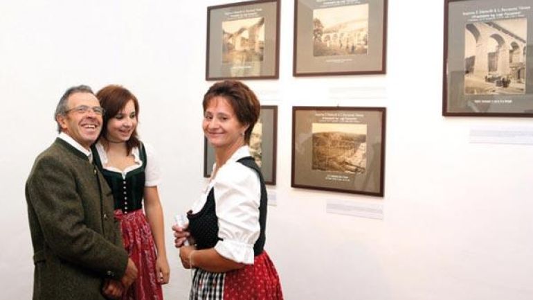 Three visitors in front of the original photographs taken by engineer Luigi Faccanoni