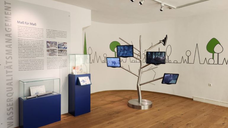 Ausstellungsraum mit Schaukästen und Bildschirmen