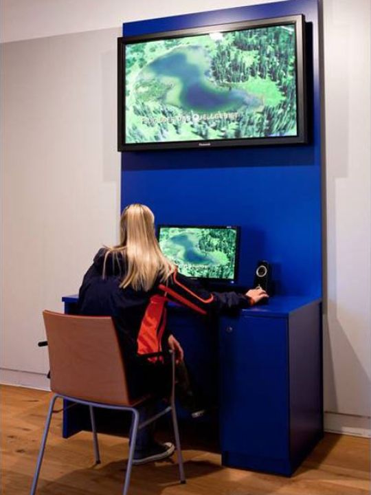 Besucherin in Raum 8 mit interaktiver Mediathek