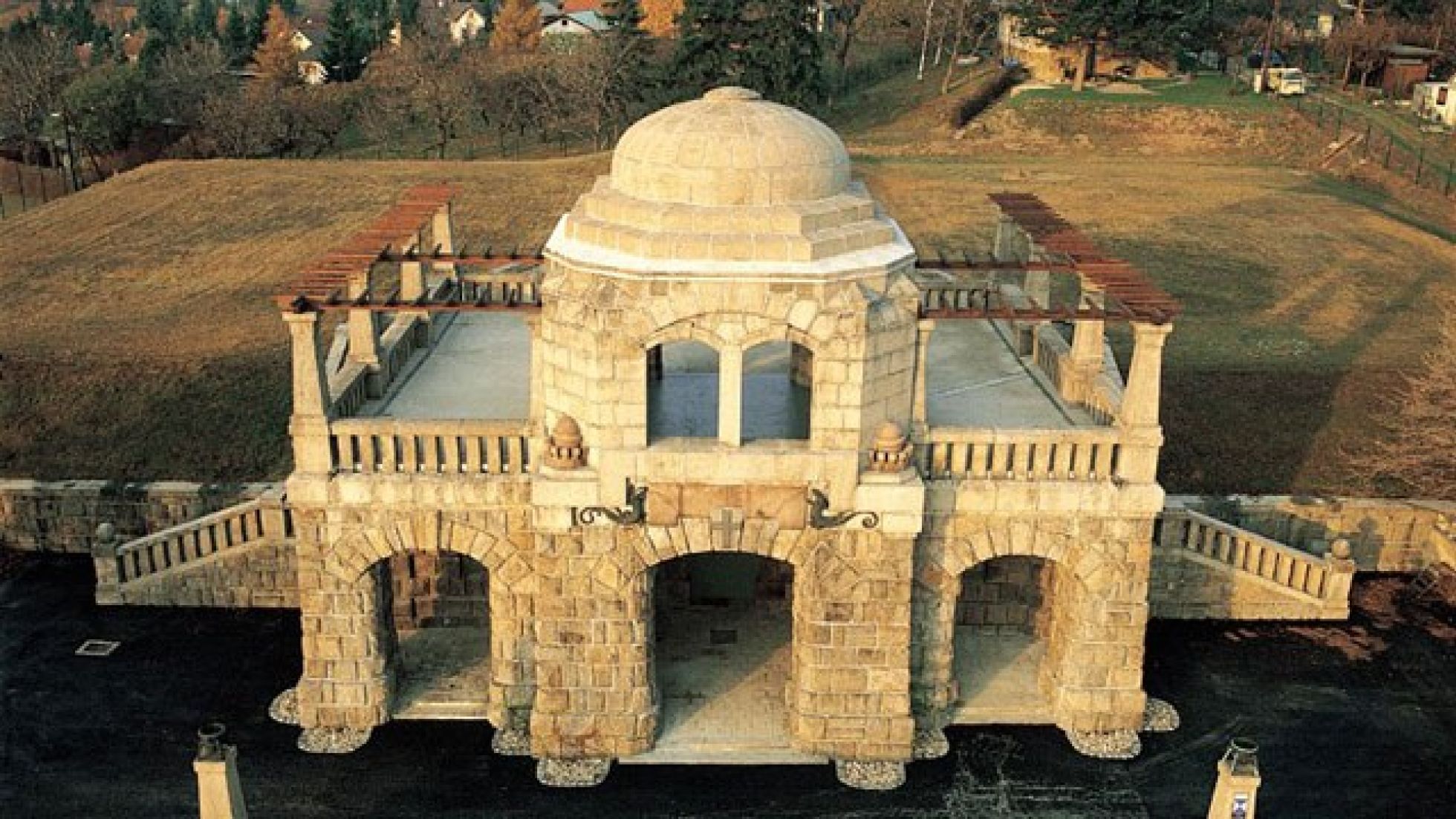 Steinernes Gebäude mit Kuppel, Terrasse am Dach, 2 Außentreppen und einem Arkadengang