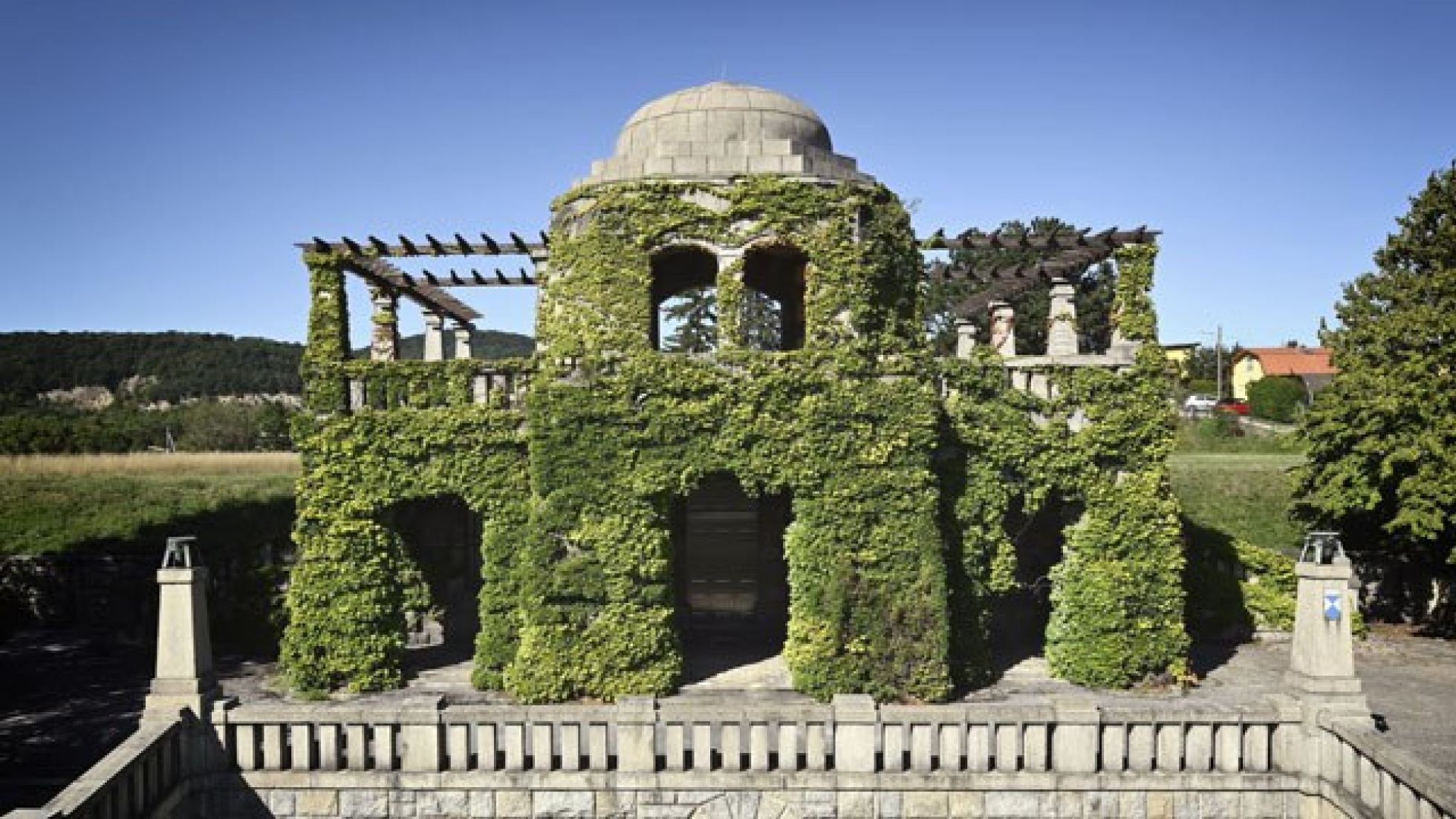 Mit Kletterpflanzen bewachsenes Steingebäude.
