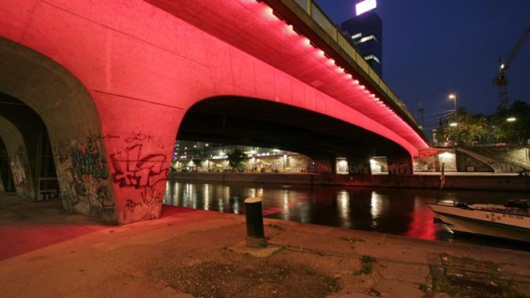Unterseite einer rot angestrahlten Brücke