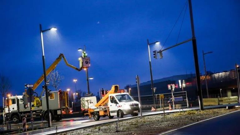 MitarbeiterInnen der MA 33 arbeiten mit Kranwägen an den neuen Standardleuchten bei Dunkelheit