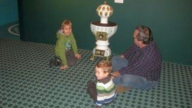 Mann mit Kindern sitzt vor einem Ofen