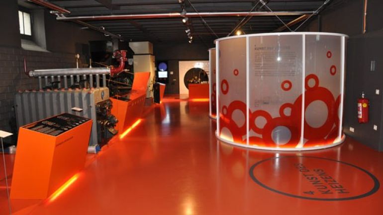 Oranger Ausstellungsraum mit großem Ofen