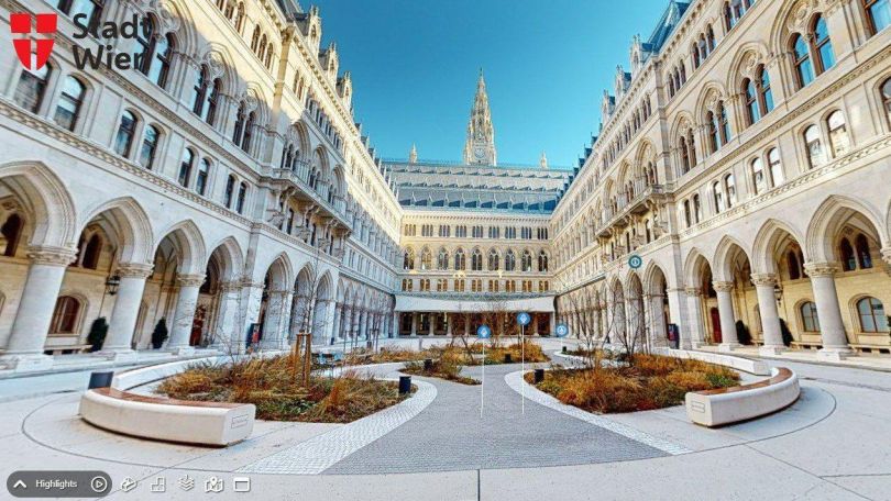 Screenshot des Arkadenhofs im Wiener Rathaus mit bunten Symbolen in der Mitte und einer Navigationsleiste unten.