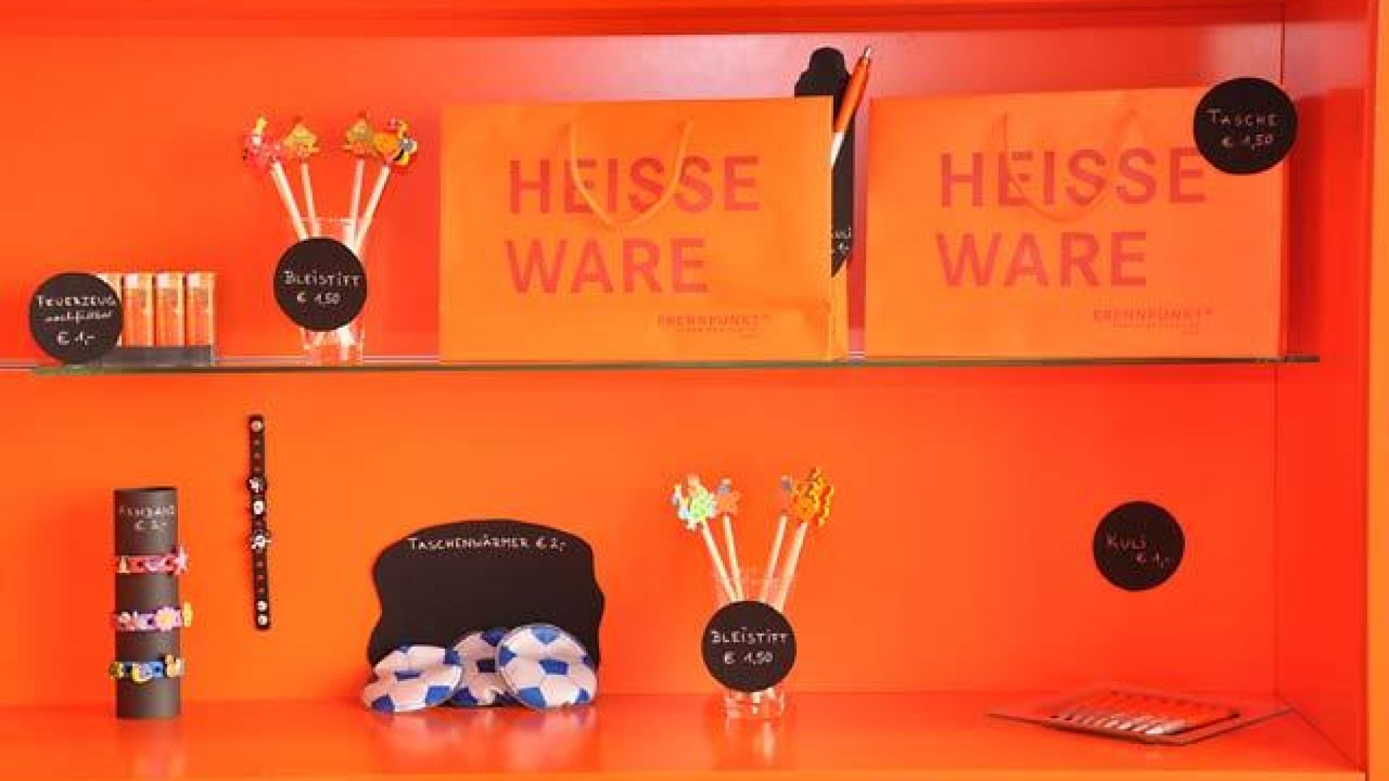 copyright: MA 34 - Bau- und Gebäudemanagement Rack with various pieces of merchandise from the Brennpunkt museum shop.