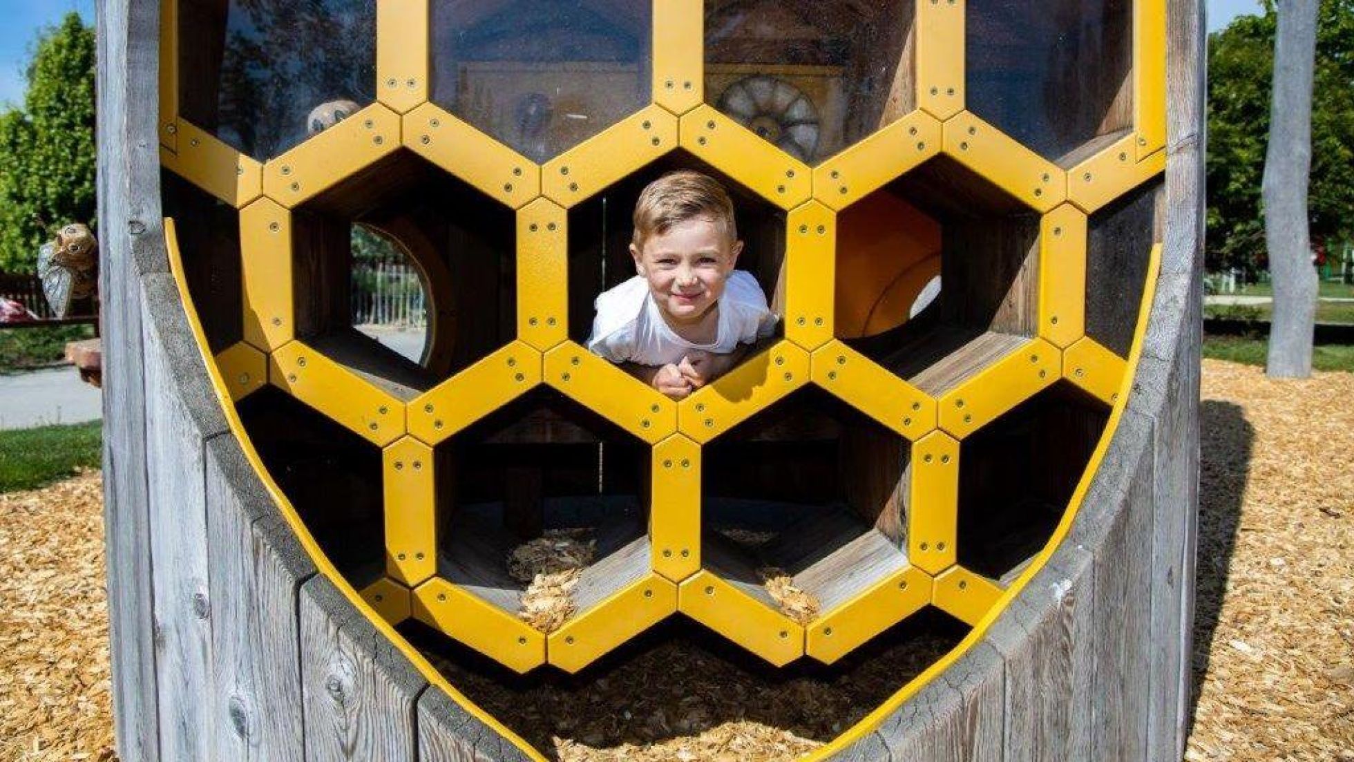 Bub in einem Spielplatzgerät in Form einer Bienenwabe