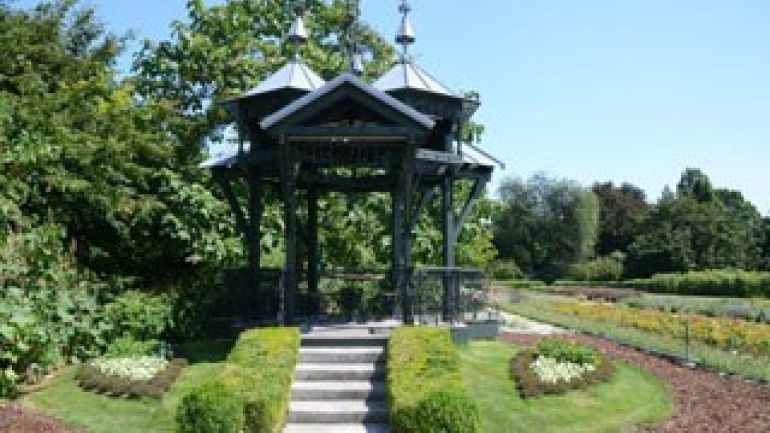 Metallpavillon, von Blumenbeeten umgeben