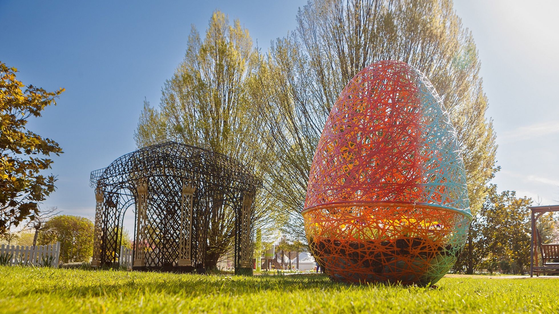 1 großes Osterei aus Metall neben einem Pavillon