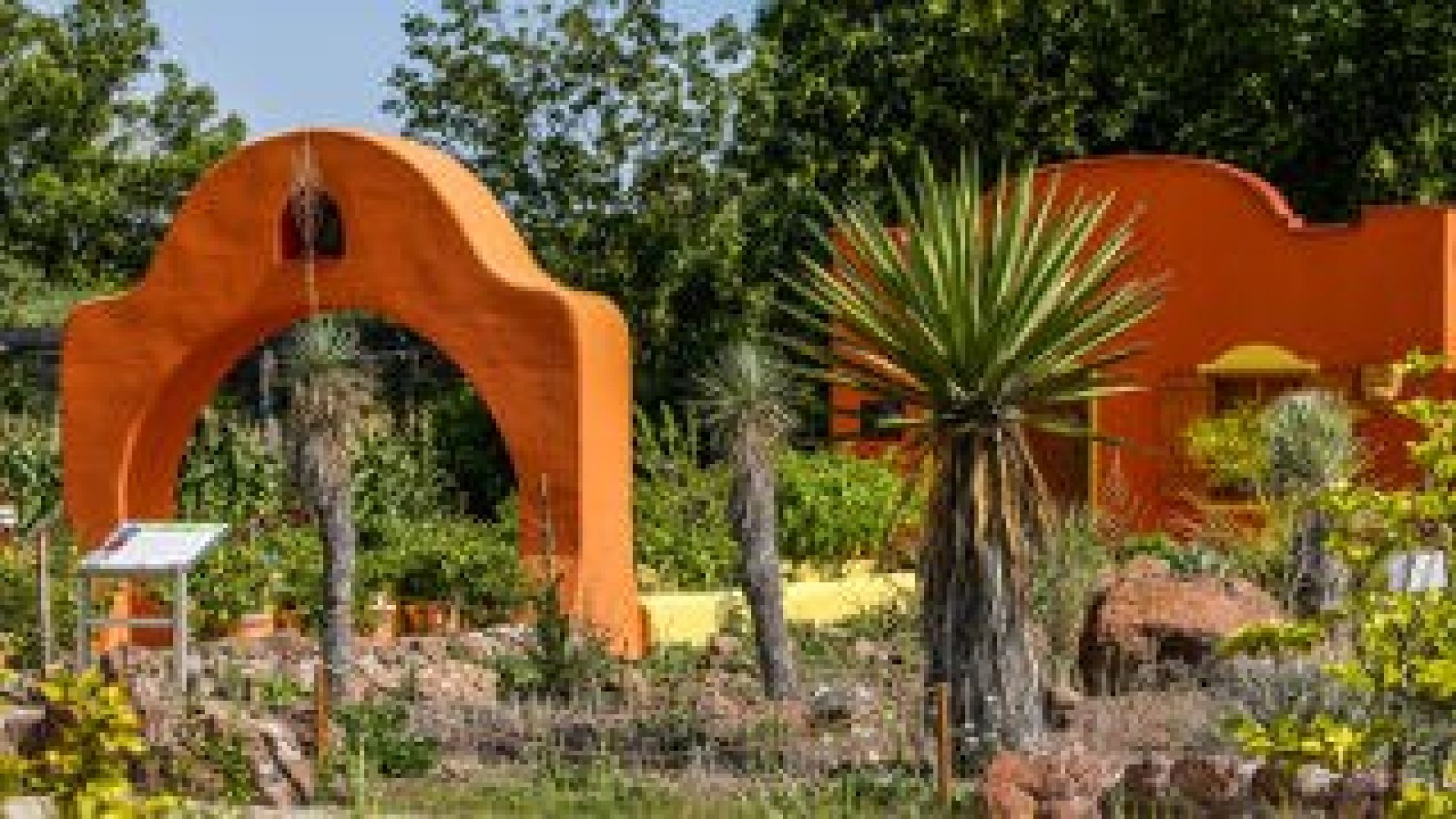 Palmen im Vordergrund, eine Hacienda im Hintergrund