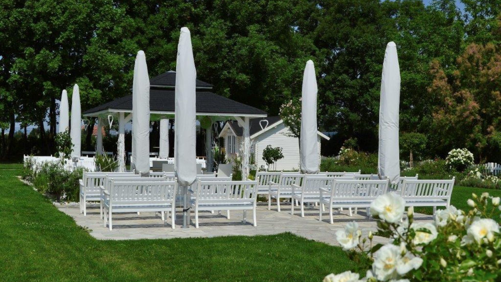 Weiße Sitzbänke und Sonnenschirme