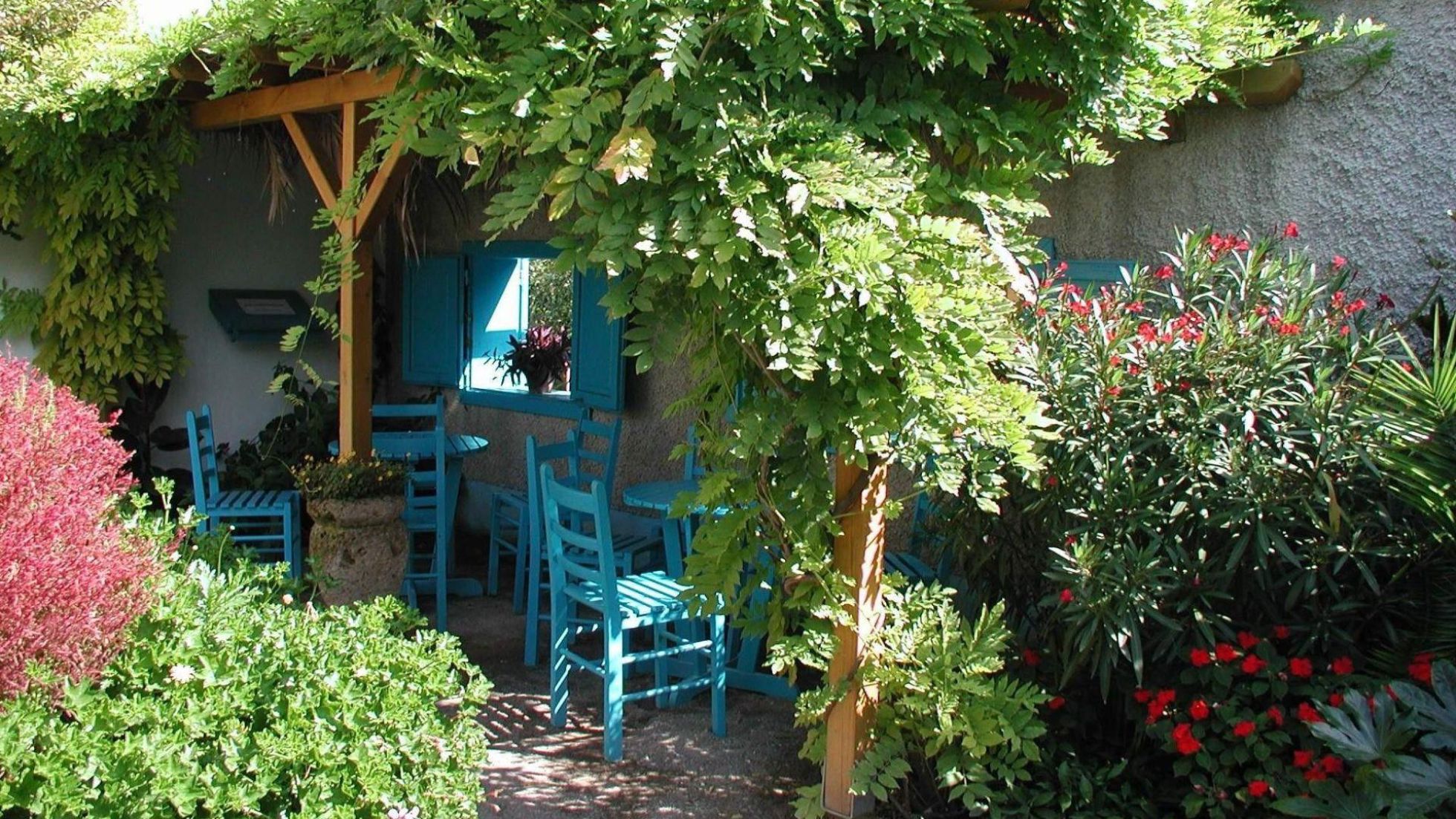 Greek garden with blue tables and chairs