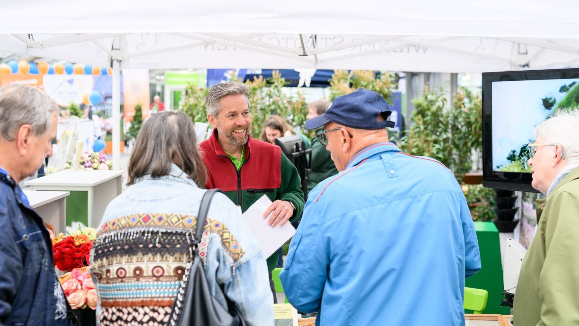 copyright: KLAUS RANGER Stadtgärten-Mitarbeiter berät Besucher der Kleingartenmesse bei Infostand