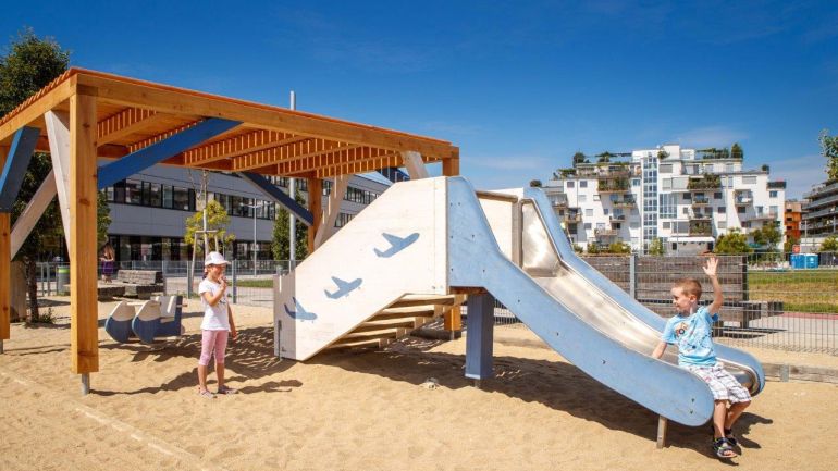 2 Kinder bei einer Rutsche auf einem Spielplatz