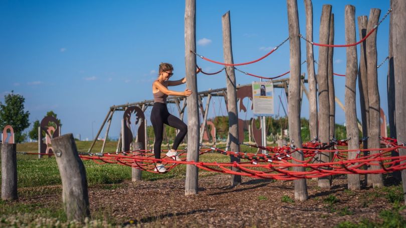 Eine Frau auf einem Balancier-Parcours mit Seilen