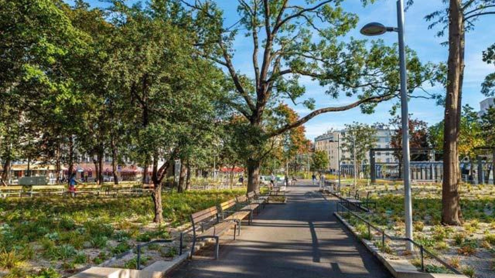 Park mit Sitzbänken und Bäumen