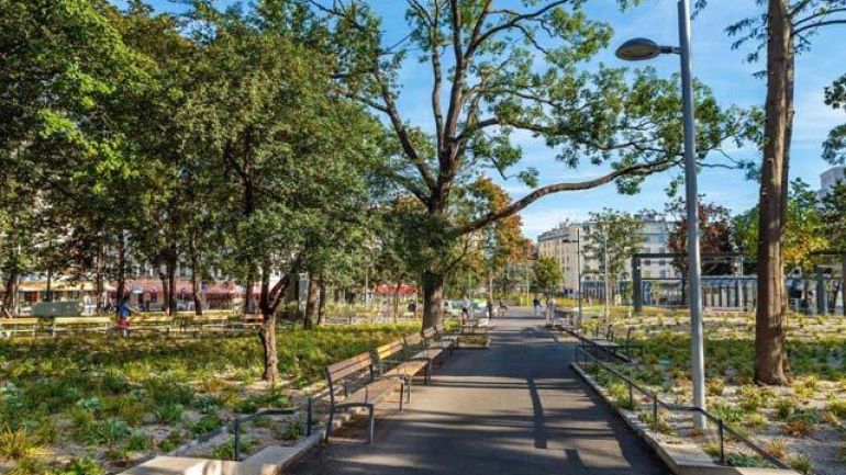 Park mit Sitzbänken und Bäumen