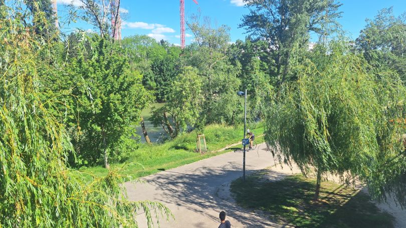 Parkanlage mit Wegen, im Hintergrund der Donaukanal