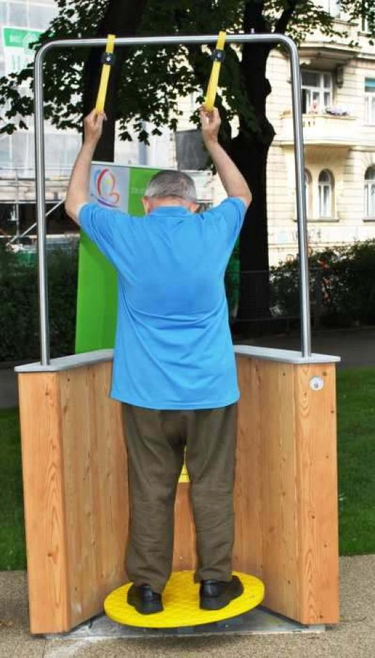 Ein Herr trainiert an der Balancescheibe