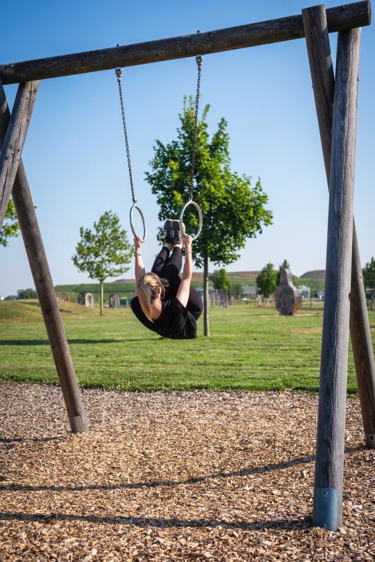 Mädchen schwingt an Ringen
