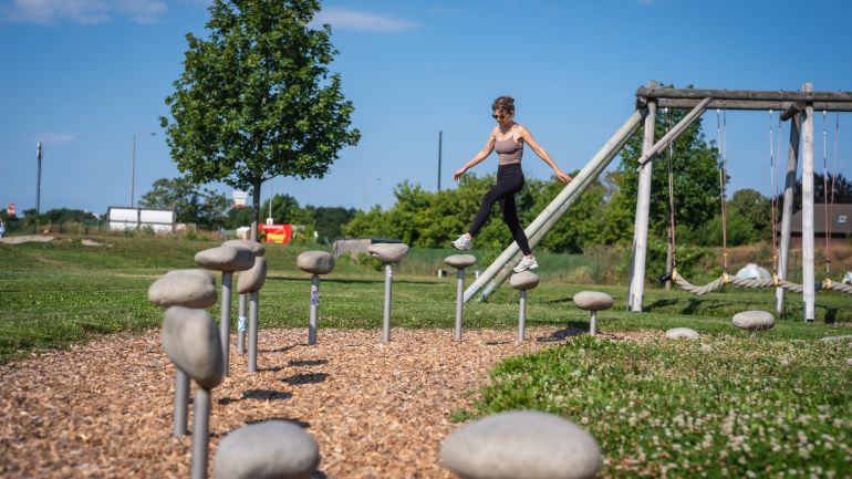 Eine Person geht über einen Balancier-Parcours