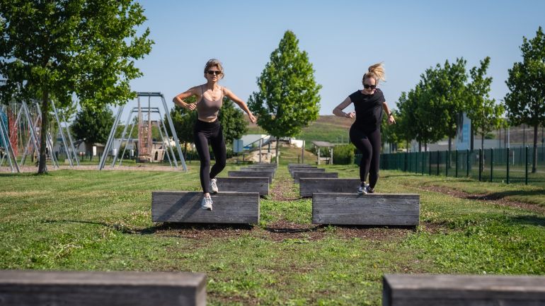 Zwei Frauen laufen über eine Hürdenstrecke