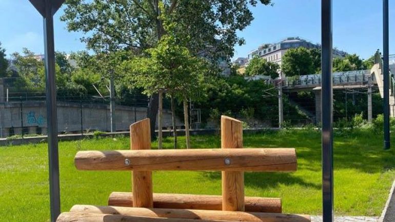 Sitzbank aus Holz unter einer Pergola