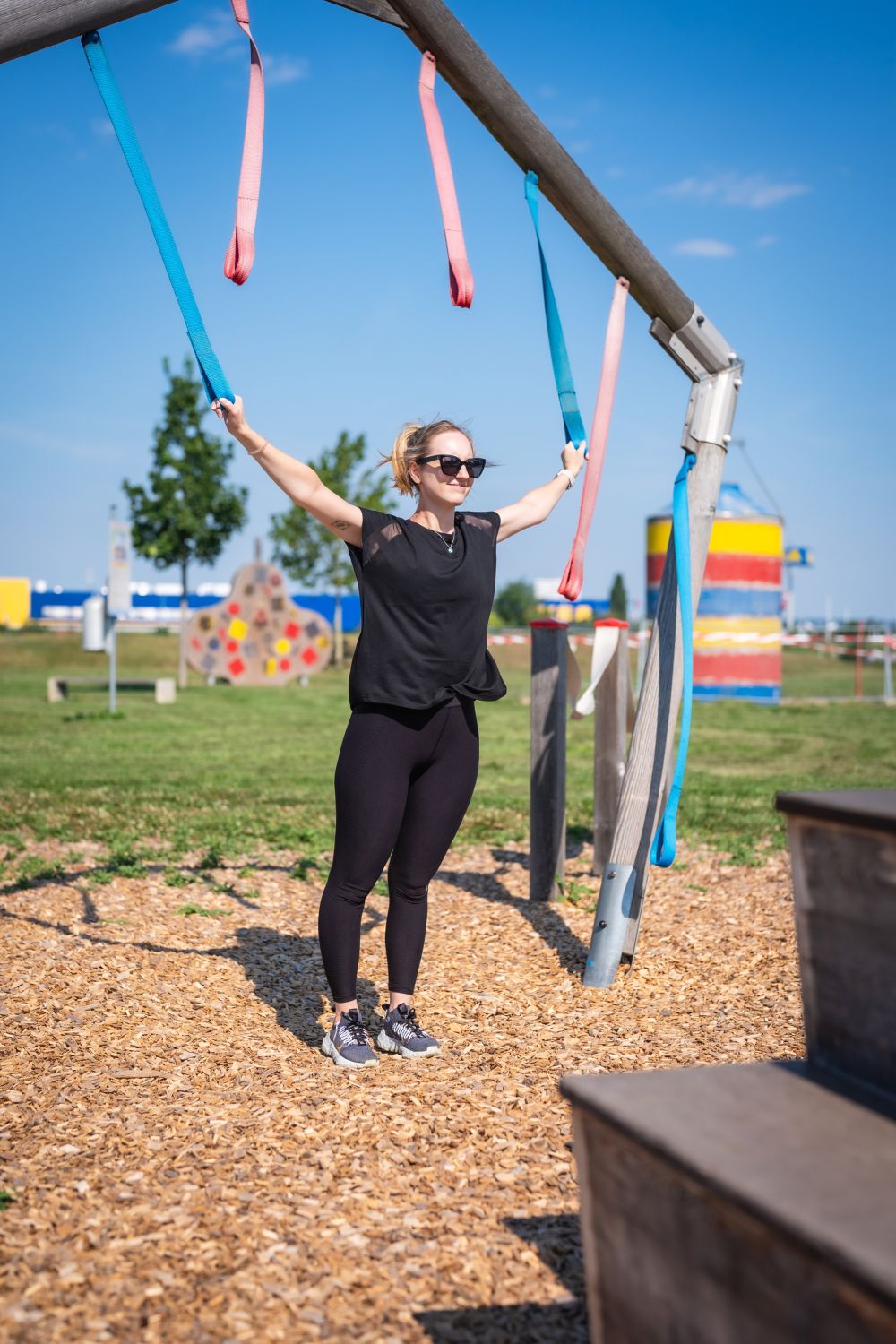 Eine Frau dehnt ihre Arme an Seilen.