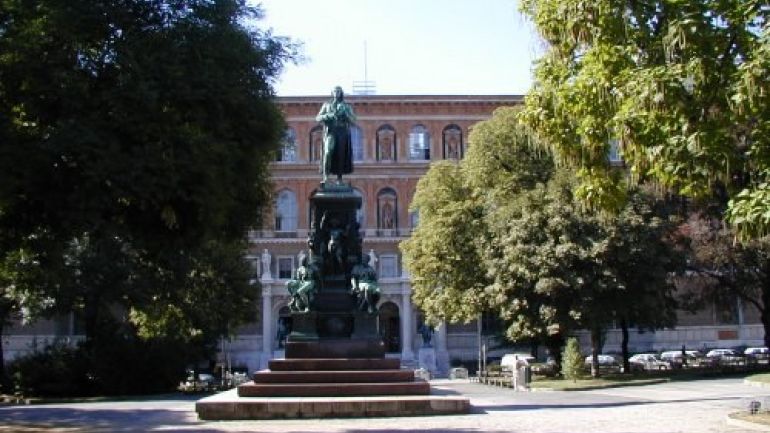 Friedrich-Schiller-Denkmal umgeben von Bäumen, im Hintergrund die Akademie der bildenden Künste