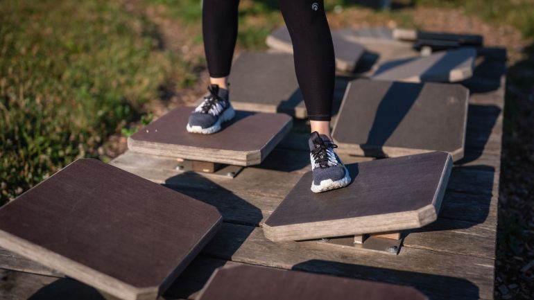 2 Beine, die in fußspurenförmige Löcher einer Platte steigen