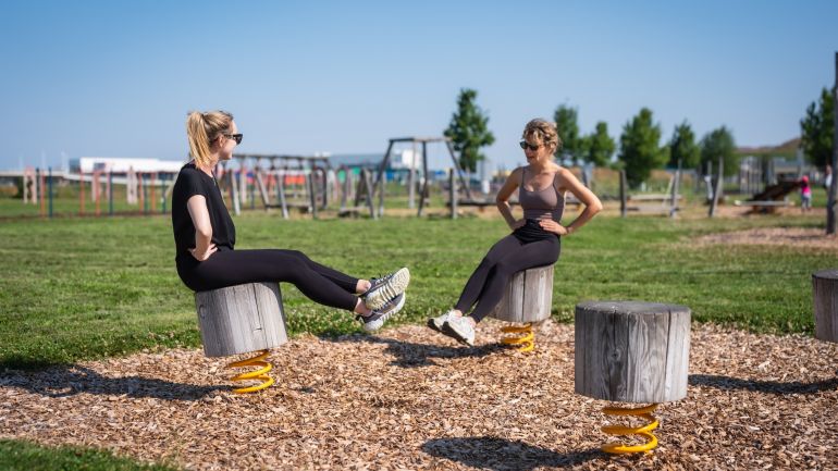 Ein Mann balanciert im Sitzen auf einem sich bewegenden Holzteil