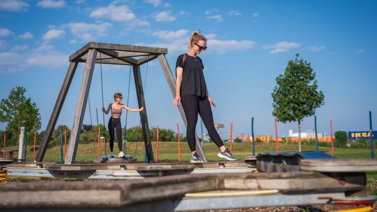 Eine Person balanciert auf einer hängenden Scheibe
