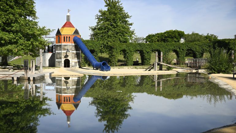 Kleiner See, dahinter Spielturm mit Rutsche