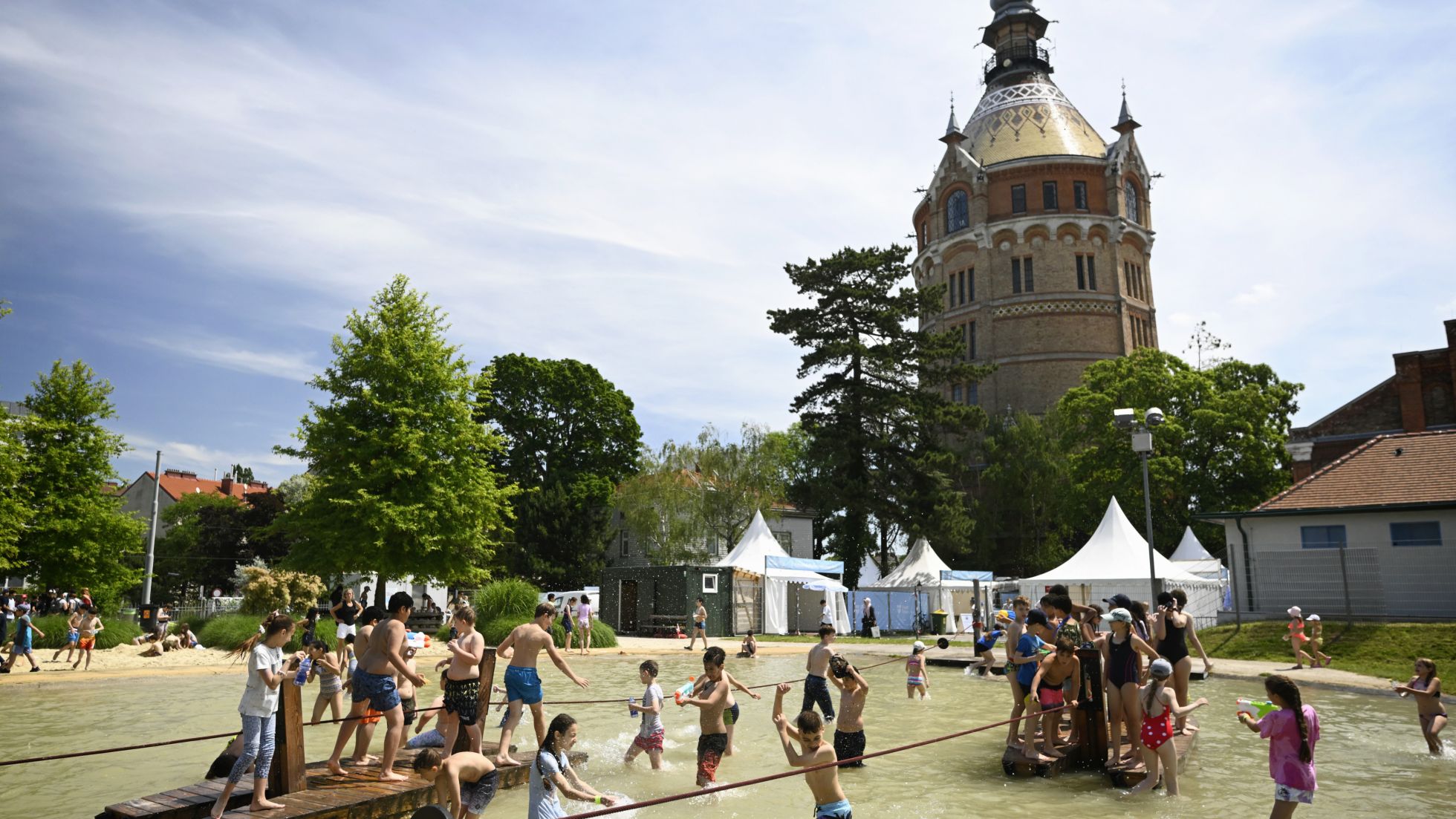 Kinder fahren mit einem Floß über einen kleinen See