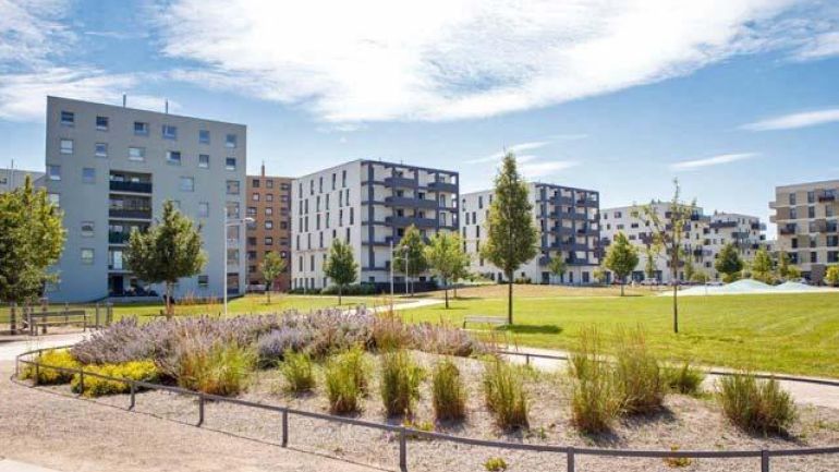 Park, im Hintergrund moderne Wohnbauten