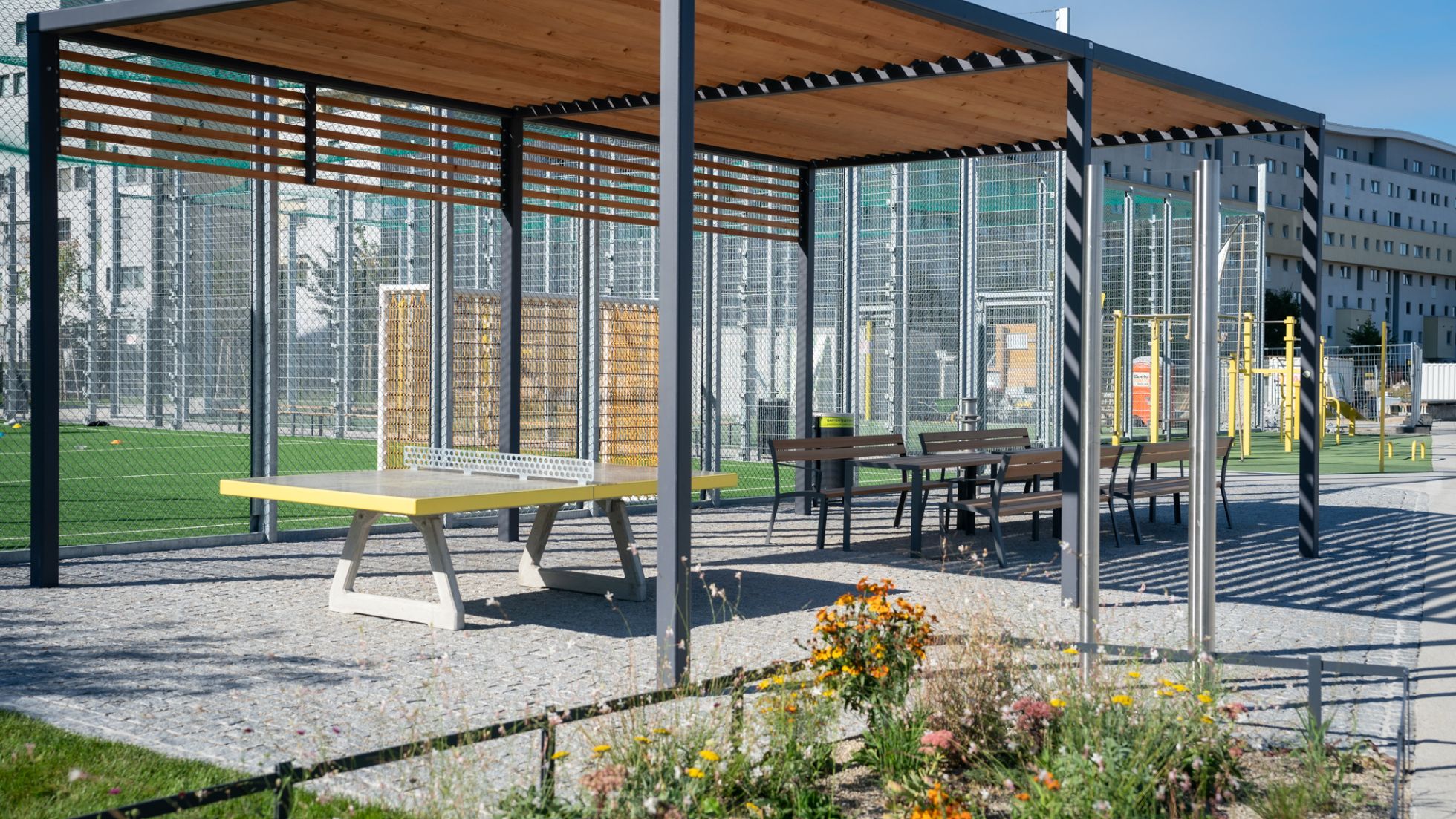 Tischtennistische und Sitzbänke unter einer Pergola