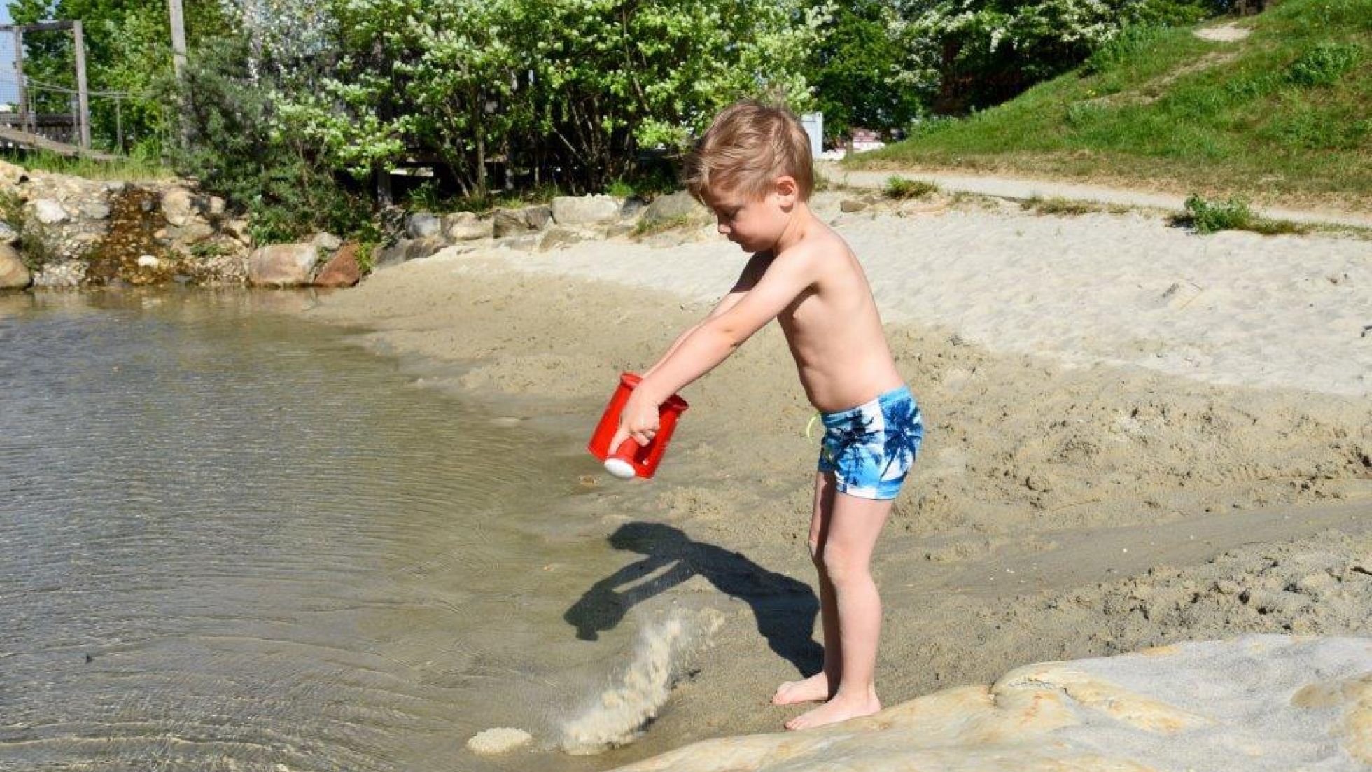 Kleinkind spielt mit einer Gießkanne