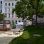 Park mit Sitzbereich links und mit Grünstreifen und Bäumen rechts