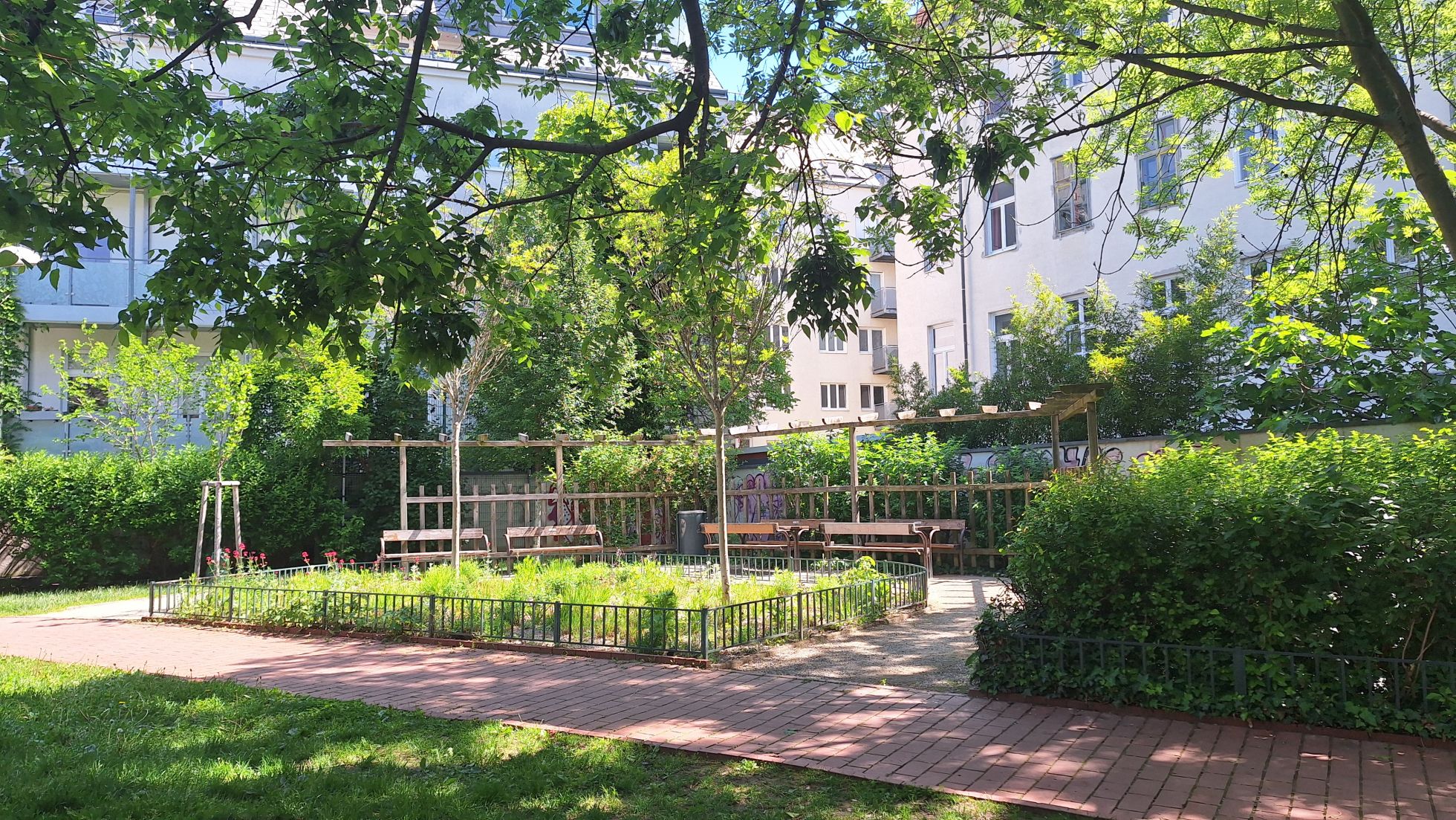 copyright: Wiener Stadtgärten Park mit Sitzmöglichkeiten neben einem Stauden- und Gräserbeet.