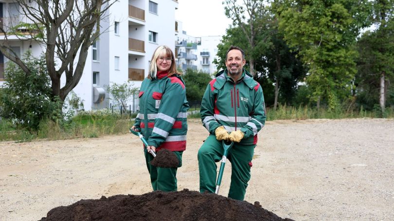 Eine Mitarbeiterin und ein Mitarbeite der Wiener Stadtgärten mit Schaufeln beim Spatenstich für den neuen Violapark.