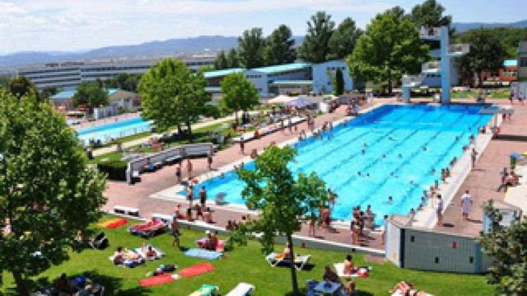 Luftaufnahme: Sommerbad mit großem Schwimmbecken und Grünflächen