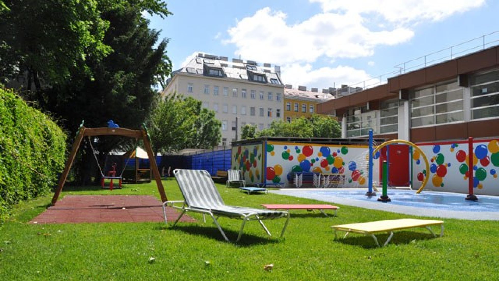 Wiese mit Liegen und Spielgeräten