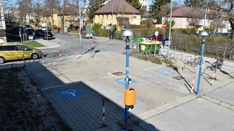 Blick von oben auf 3 Behinderten-Parkplätze vor dem Donaustädter Bad