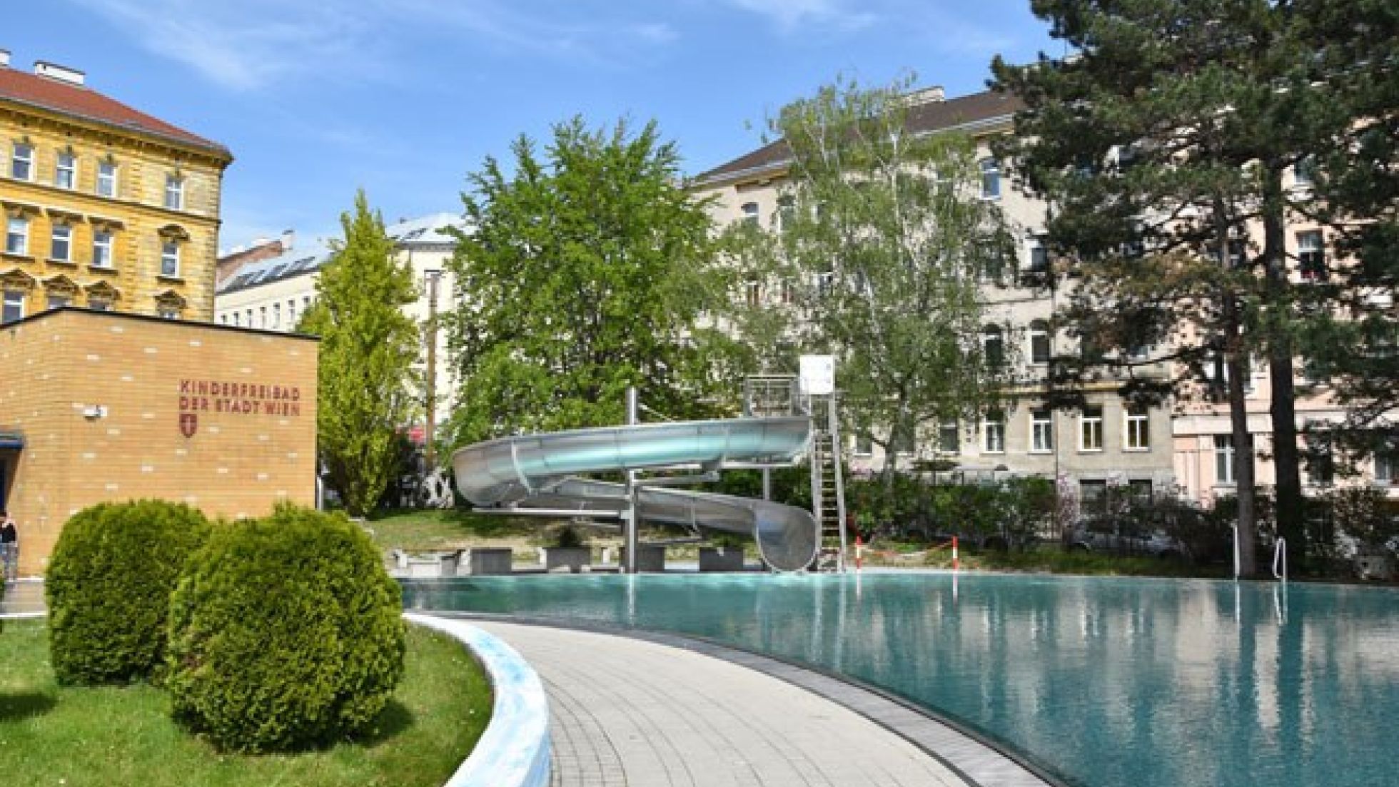 copyright: MA 44 Schwimmbecken mit Rutsche, daneben Bäume und Sträucher