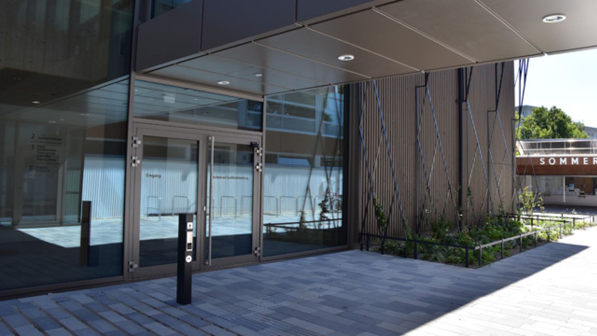 Überdachte Eingangstür, Pfosten mit Klingel links vom Eingang