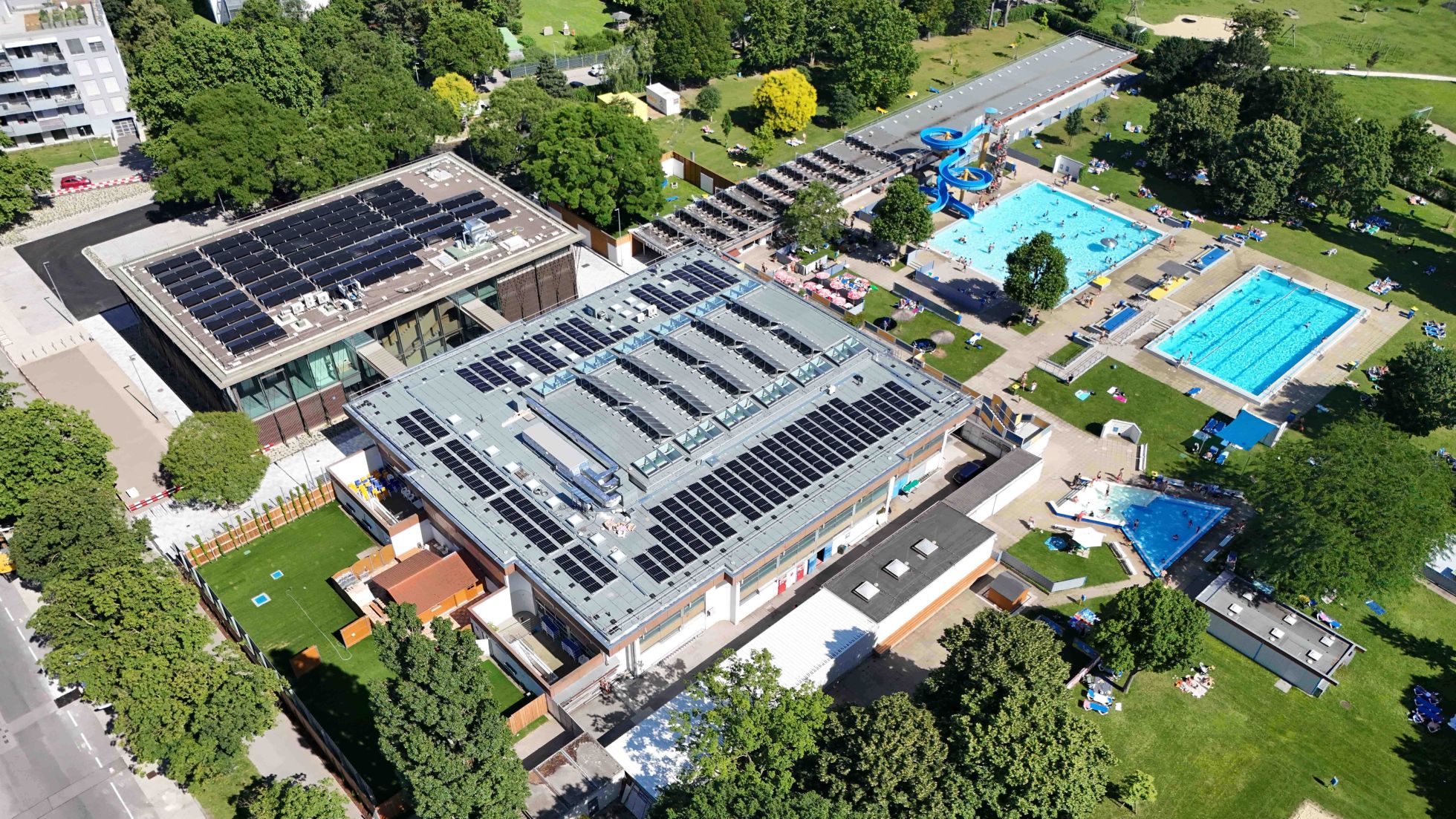 Am Dach sind Photovoltaikanlagen installiert, im Freibereich sind 2 große Schwimmbecken und ein großer Liegebereich.
