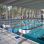 Moderne Schwimmhalle mit Schwimmbahnen und breiter Fensterfront.