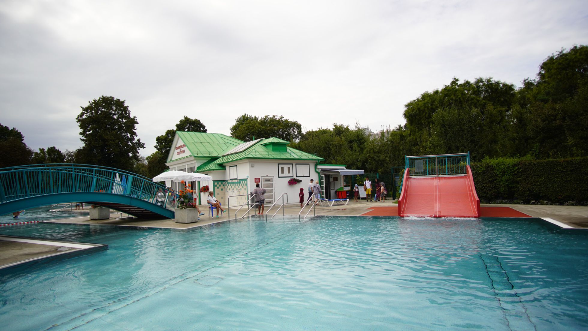 Kleines Freibad mit Rutsche und Brücke