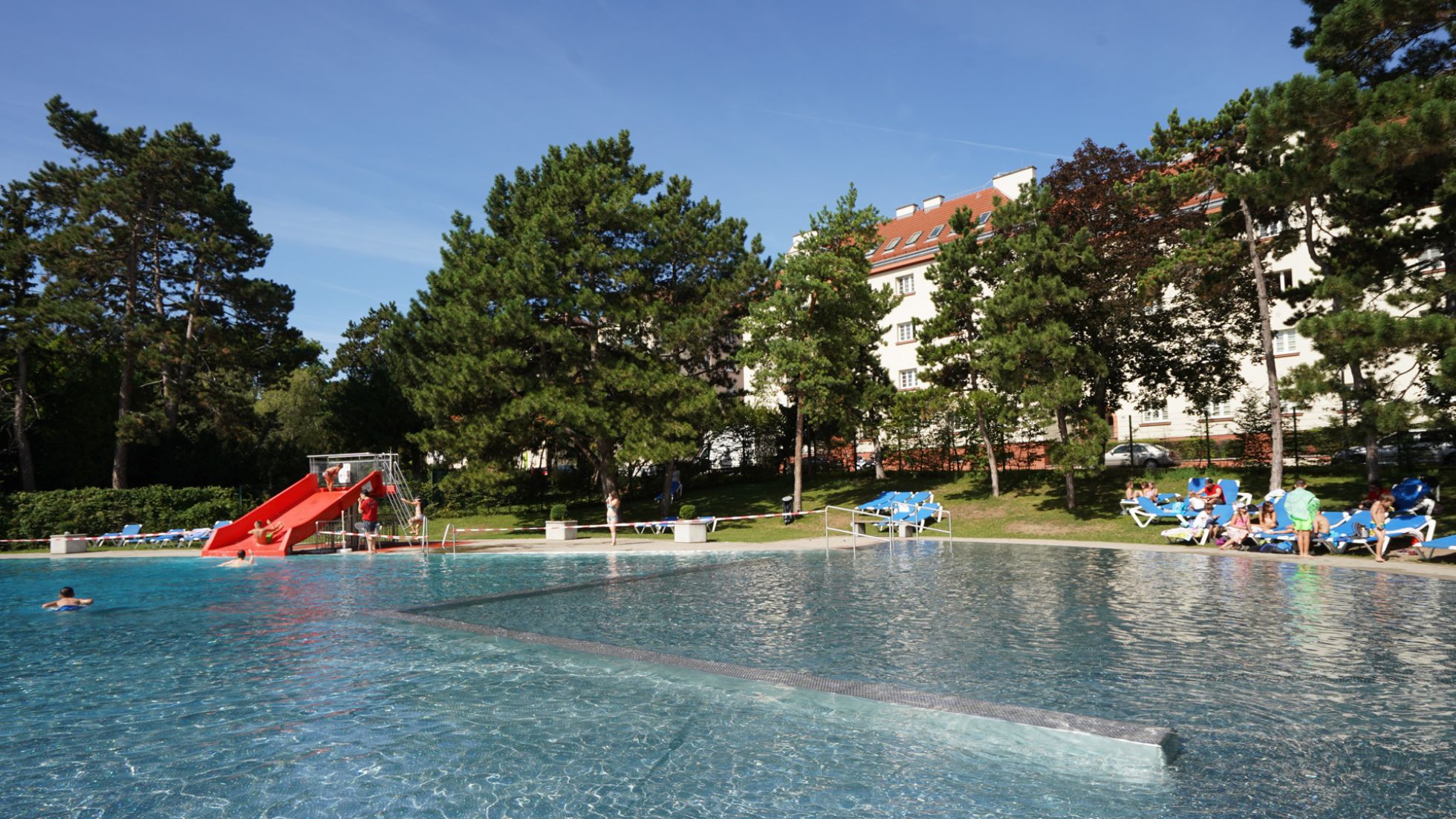 Freibecken und Liegewiese mit Bäumen